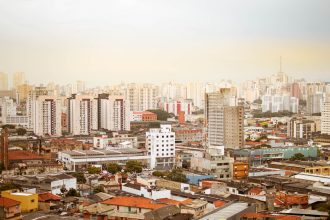 Vista aérea da paisagem urbana de São Paulo, com prédios residenciais e arranha-céus.
