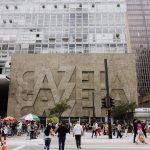 Rua movimentada diante do edifício Gazeta, na Avenida Paulista, em São Paulo.