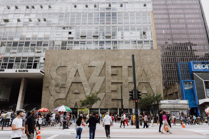 Rua movimentada diante do edifício Gazeta, na Avenida Paulista, em São Paulo.