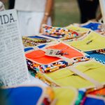 Artesanatos coloridos expostos em uma feira ao ar livre.