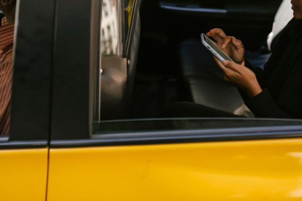 Passageiro usa um smartphone no banco traseiro de um táxi durante uma viagem.