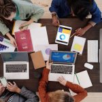 Equipe diversa trabalhando com laptops e tablets em estratégias de marketing digital.