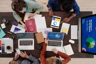 Equipe diversa trabalhando com laptops e tablets em estratégias de marketing digital.