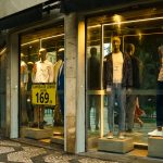 Vitrine de loja de moda masculina em São Paulo, com manequins exibindo roupas contemporâneas.