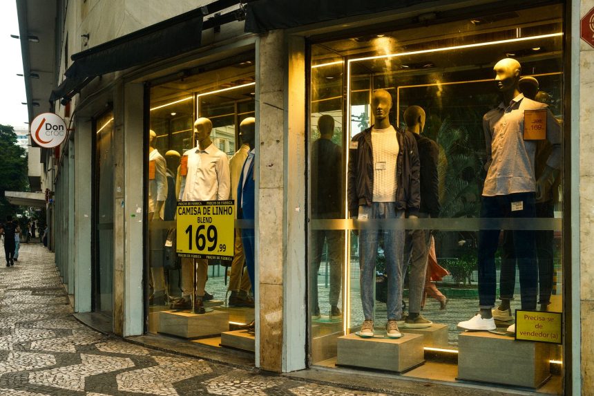 Vitrine de loja de moda masculina em São Paulo, com manequins exibindo roupas contemporâneas.
